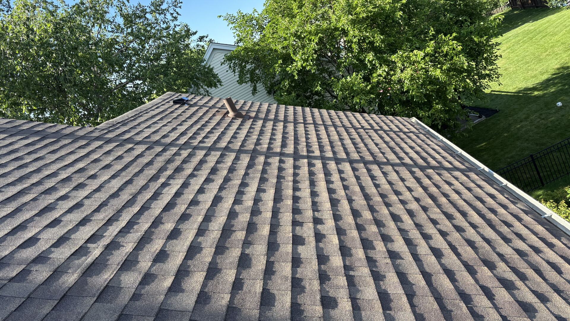 Newly installed architectural asphalt shingle roof on a Northern Illinois home, photographed from the ridge on a clear day