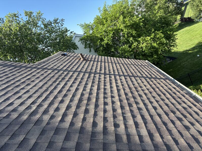 Wide view of a completed architectural shingle roof replacement on a two-story suburban home