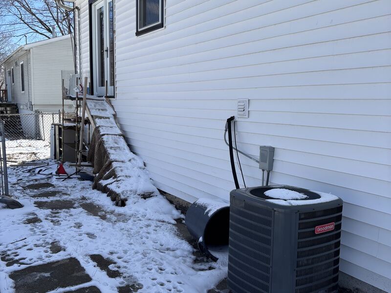 White horizontal vinyl siding on the side of a house in winter with snow on the ground